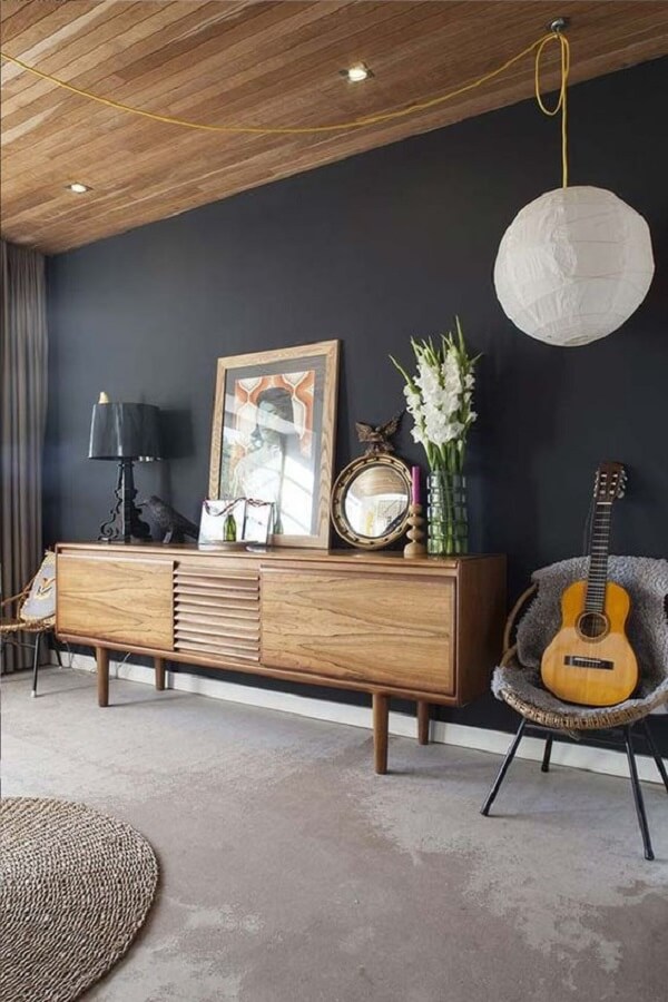 Sala com parede cinza azulado e rack de madeira