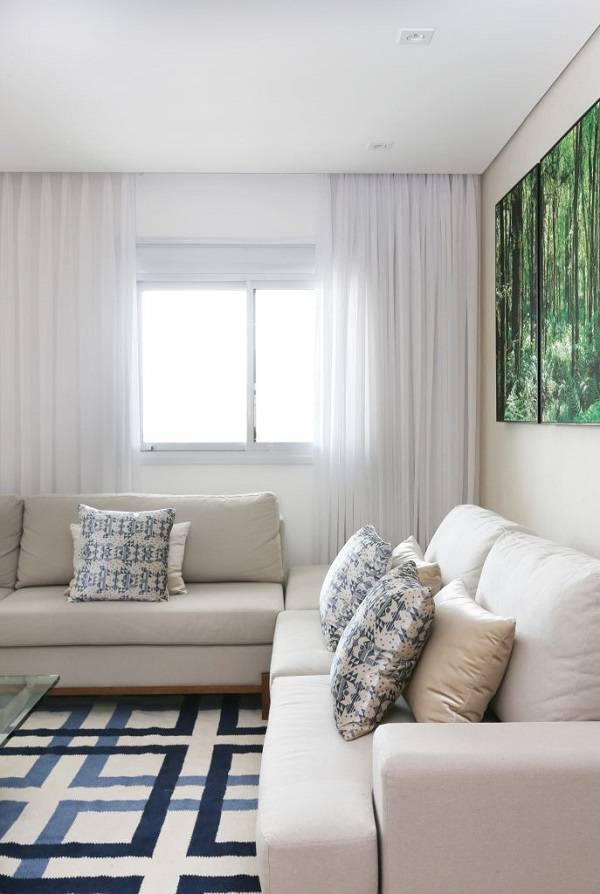 Sala confortável com cortina branca e móveis claros