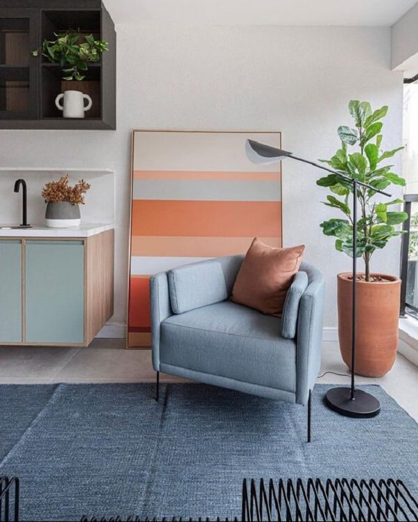 Sala de estar com tapete cinza azulado e detalhes em laranja