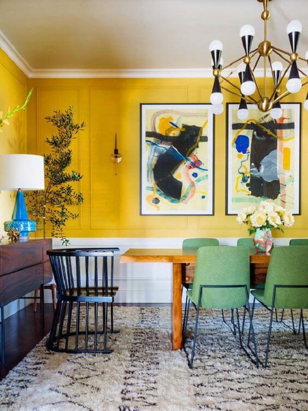 Sala de jantar grande decorada com tons de amarelo e luminária retrô