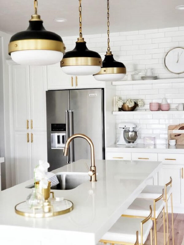 Bancada de granito claro com detalhes da cozinha luxuosa em dourado e preto