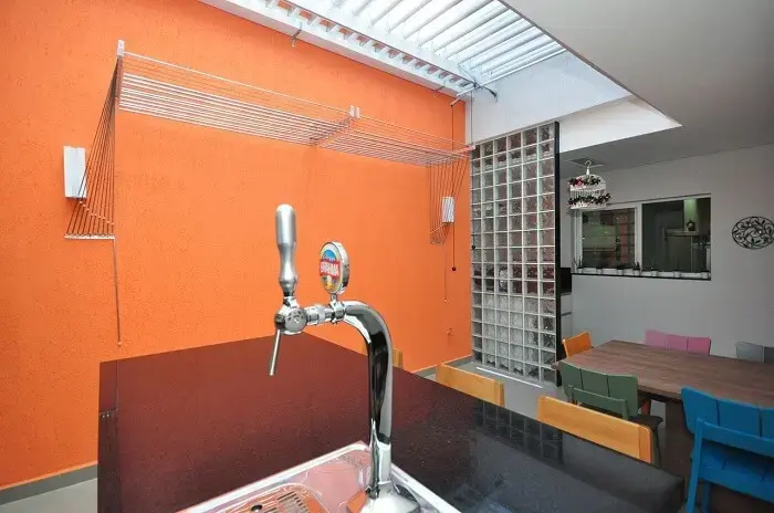 Área de serviço externa com parede laranja. Projeto de Condecorar Arquitetura e Interiores