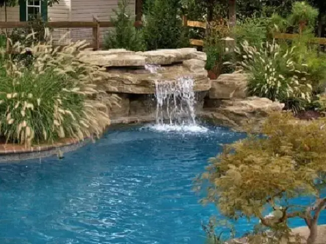 A cascata para piscina de pedra pode ser construída de diferentes maneiras.
