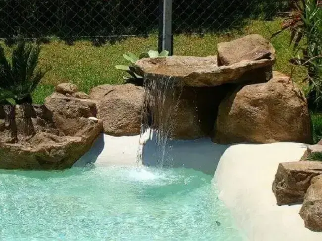A cascata para piscina de pedra traz charme para a área de lazer