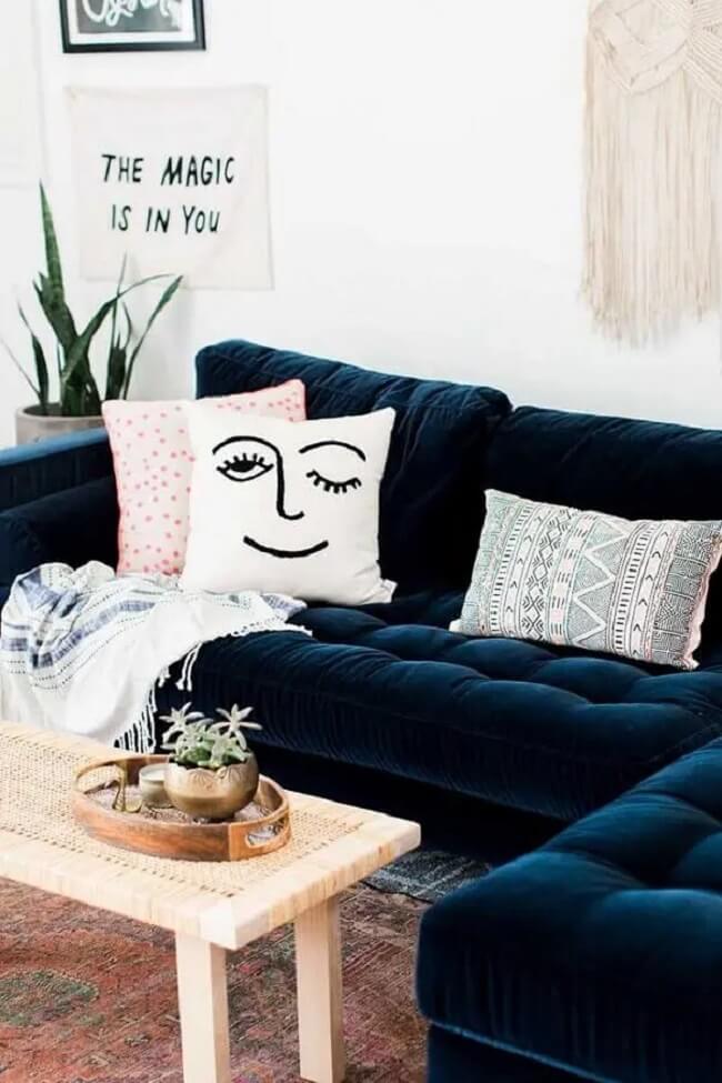As almofadas estampadas decoram o sofá de canto capitonê azul marinho