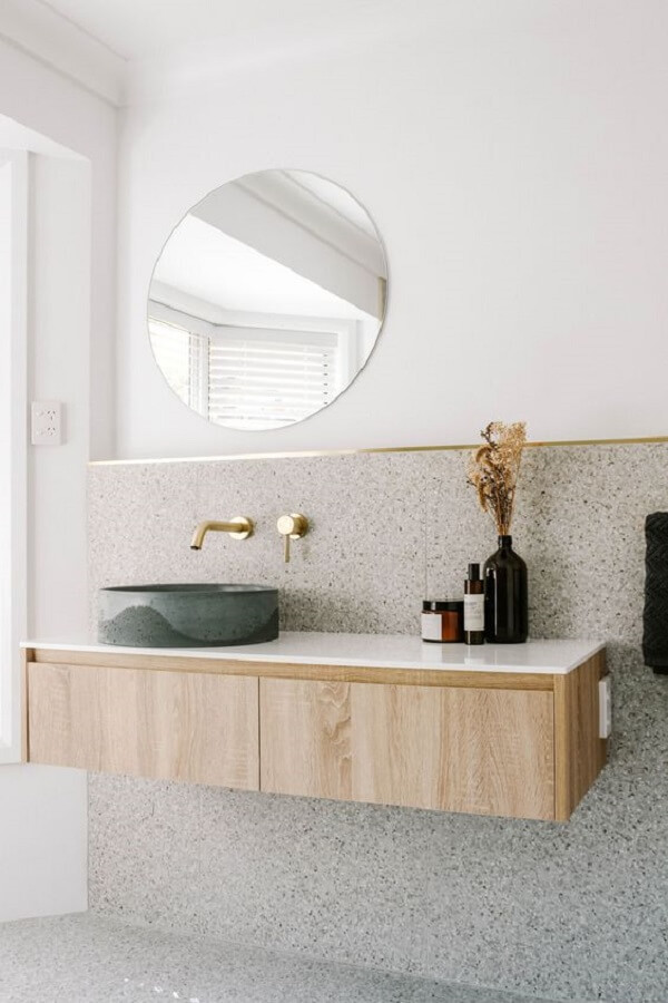 Banheiro moderno com torneira dourada de parede