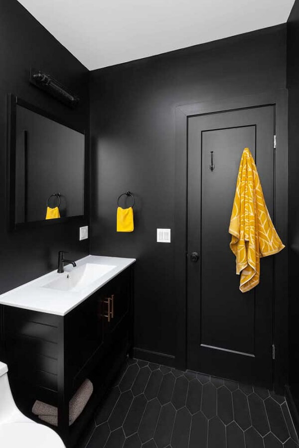 Banheiro na cor preta com porta preta e detalhes em amarelo