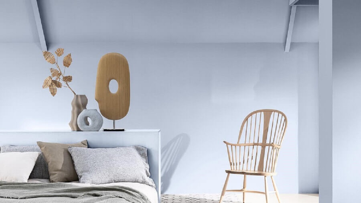 Decoração clean para quarto com cadeira de madeira e parede azul claro Foto Coral
