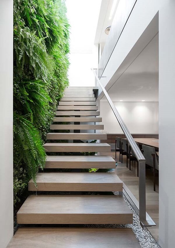 Jardim embaixo da escada com parede verde