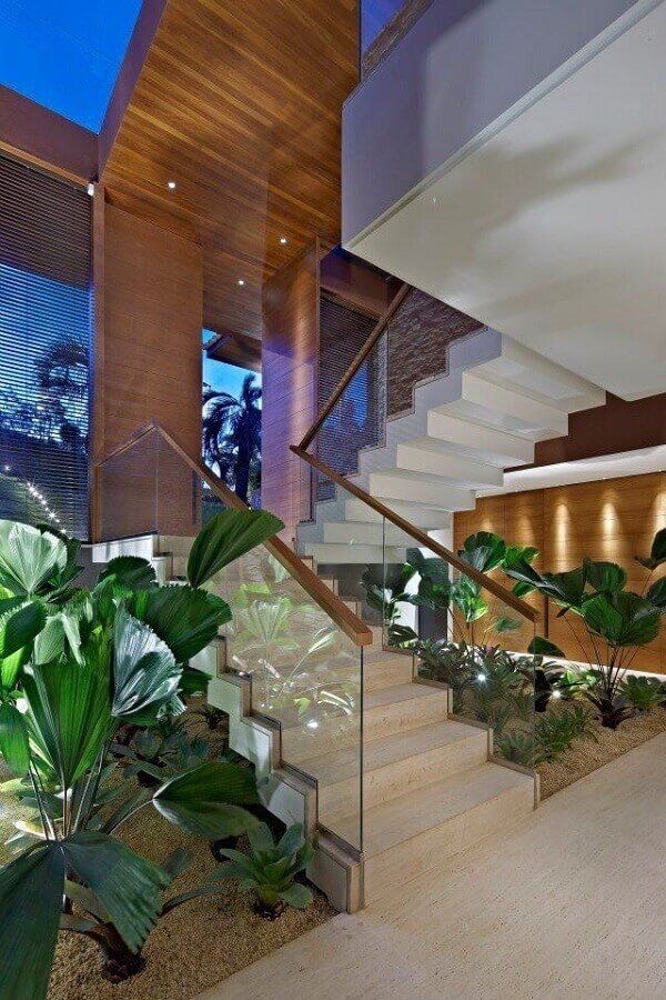 Jardim embaixo da escada com porta corpo de vidro