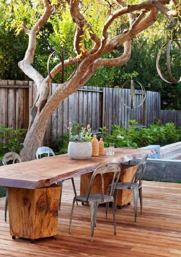 Mesa de jardim de madeira rustica com luminária redonda de jardim na árvore