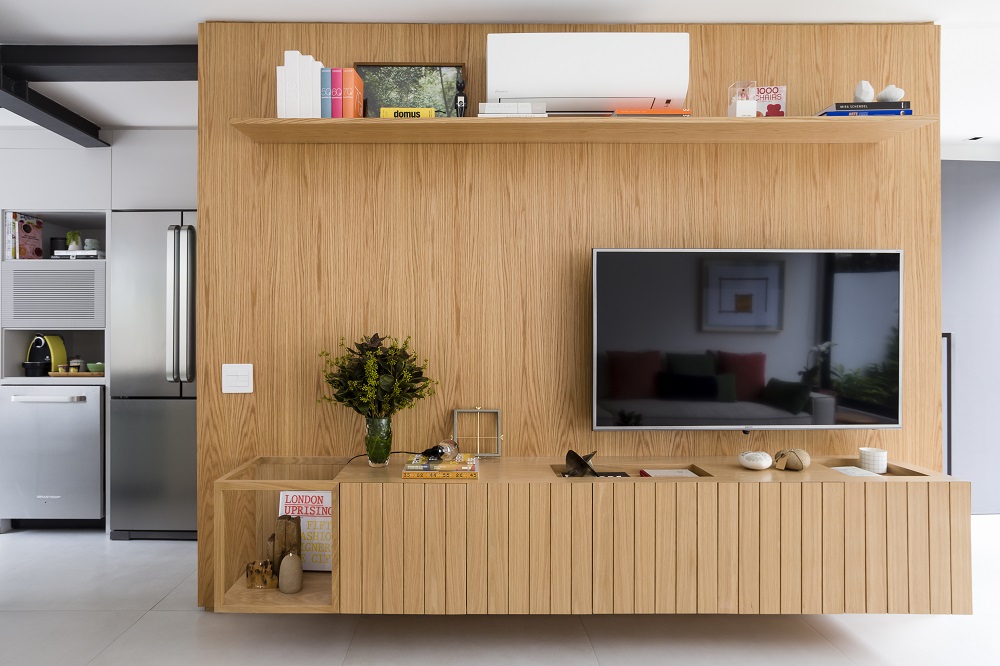 O painel da TV de madeira traz um toque de aconchego para o ambiente. Foto: Ricardo Bassetti