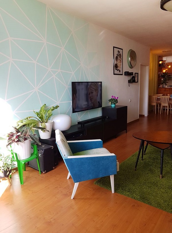 Papel de parede verde água para sala de estar com poltrona azul e tapete verde