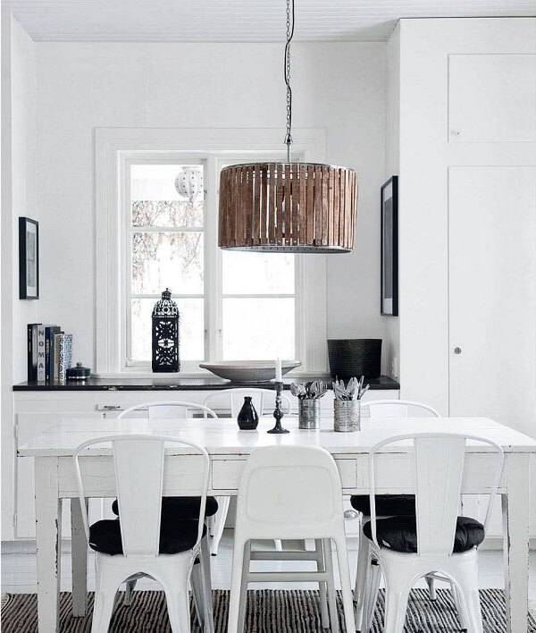 Sala de jantar branca e preta om luminária redonda de madeira