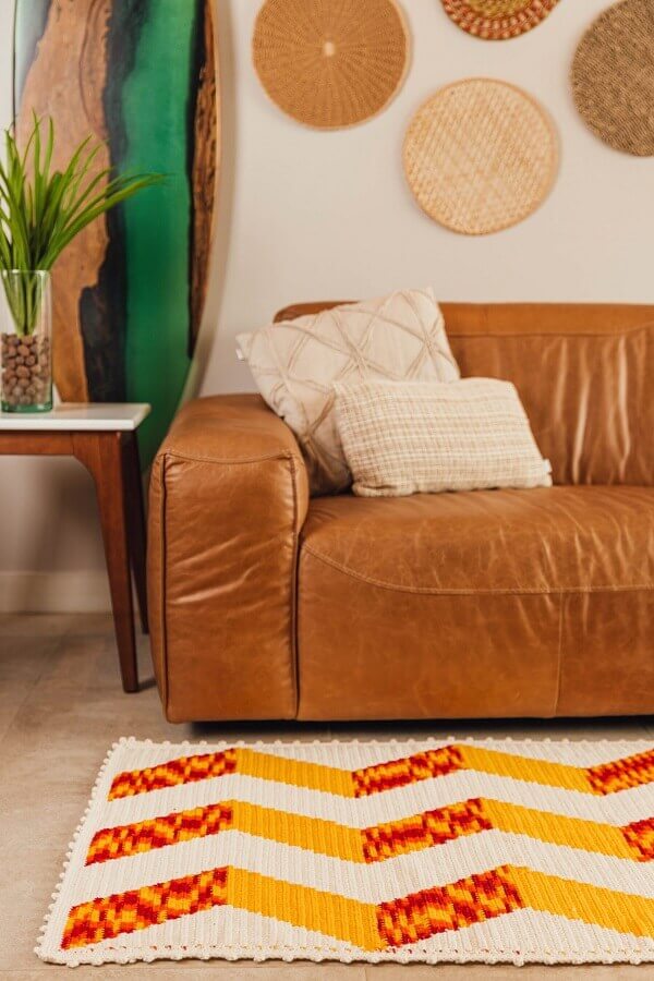 Sala decorada com sofá de couro e tapete colorido artesanal Foto Circulo