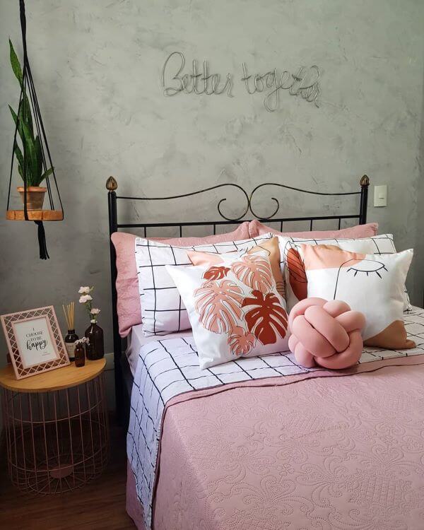 Cama decorada com almofadas grandes em tons de rosa e branco e camas diferentes