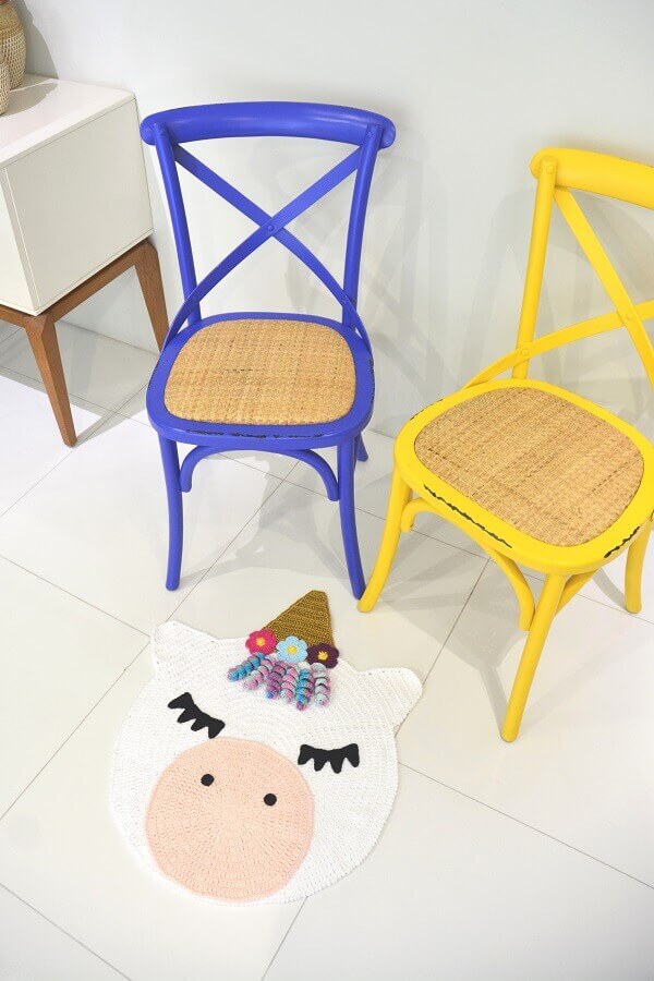 Decoração clean com tapete unicórnio e cadeiras coloridas Foto Circulo