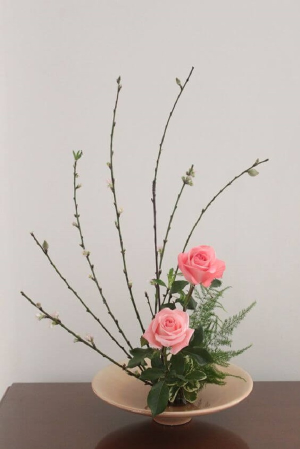 Ikebana com flores rosa e detalhes delicados