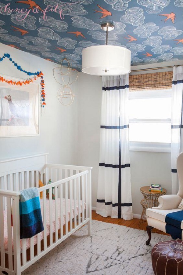 Quarto de bebe com papel de parede para teto em azul e laranja