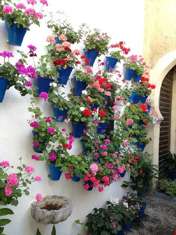 Quintal pequeno decorado com vasos flores coloridas de gerânio