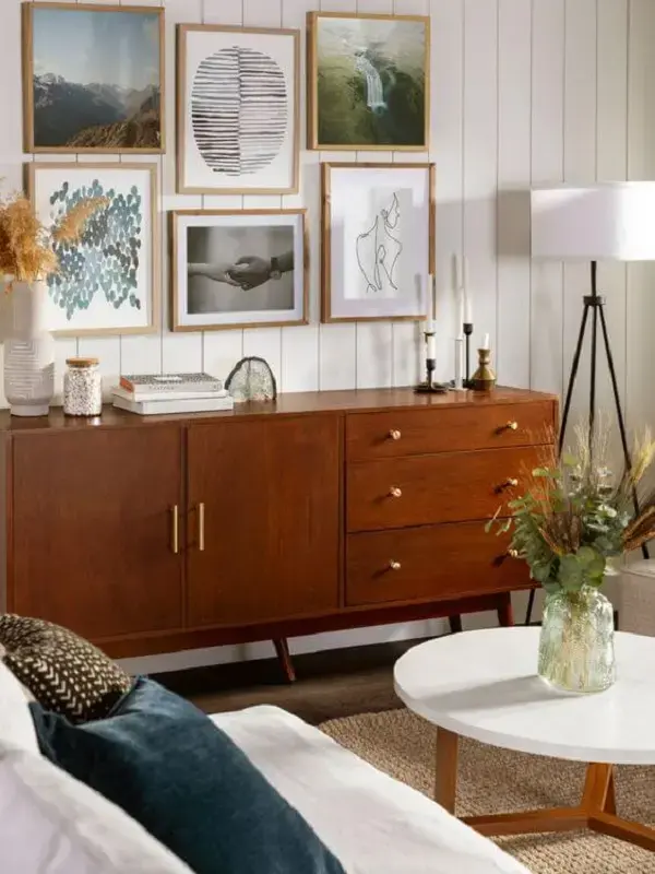 Rack minimalista de madeira na sala de estar com quadros e móveis confortáveis