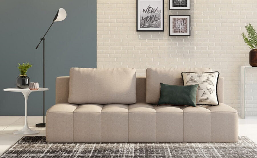 Sala clean decorada com sofa cama cinza e parede tijolinho Foto TokEStok