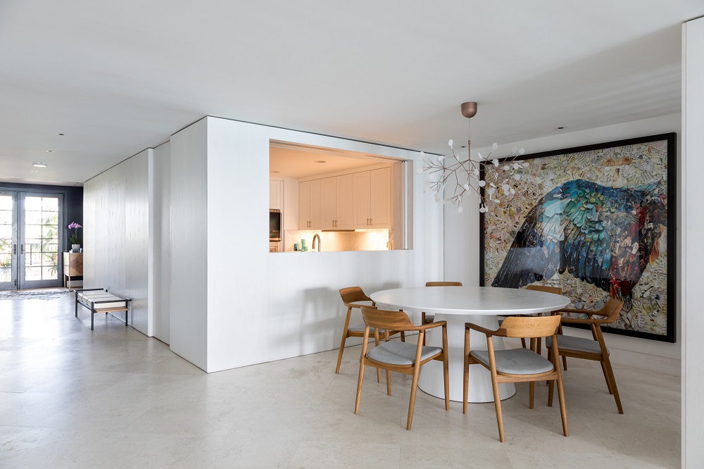 A cozinha integra-se ao living a partir de uma abertura na parede. Foto: Fran Parente