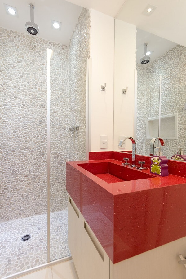 Banheiro com cuba de granito vermelho e gabinete branco