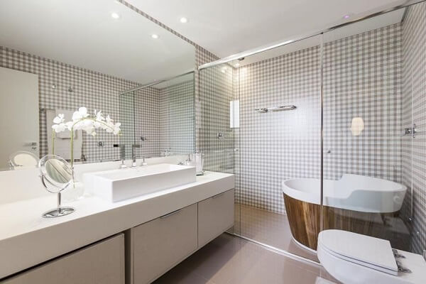 Banheiro com papel de parede listrado e bancada branca 