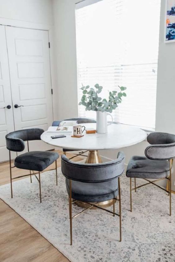 Base para mesa de jantar dourada com cadeiras cinza