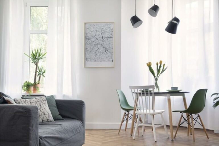 Cores claras para decoração de apartamento simples com mesa redonda e cadeiras diferentes