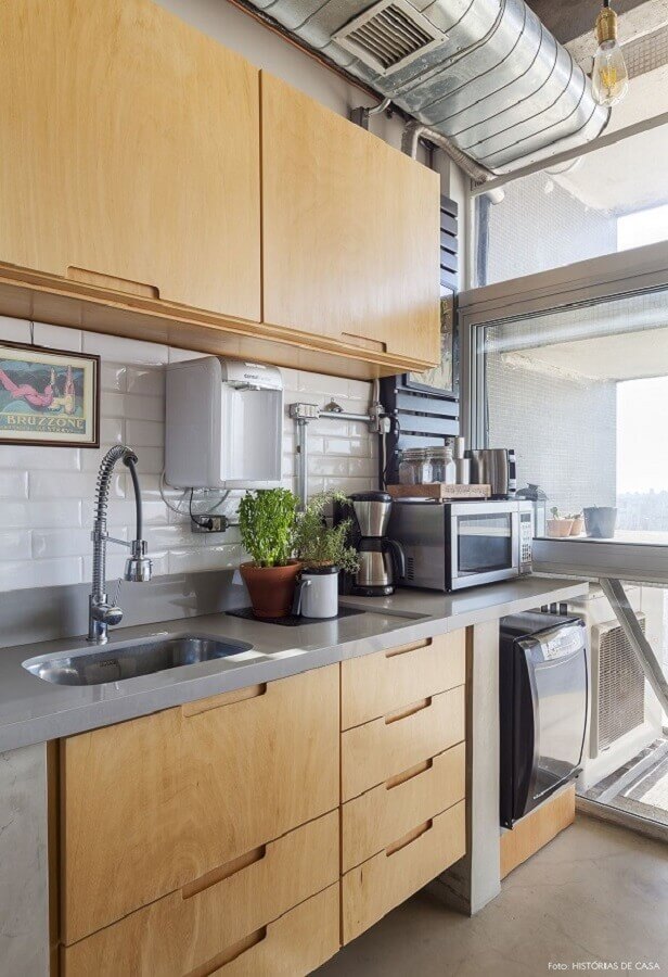 Cozinha com bancada de quartzo cinza claro decorada com armários de madeira Foto Histórias de Casa