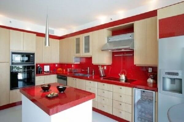Cozinha com revestimento de granito vermelho na bancada e na parede