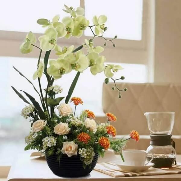Decoração com arranjo de flores artificiais para mesa de jantar. Fonte: De Lavie Decor
