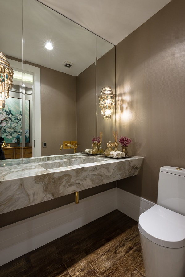 Decoração luxuosa de lavabo embaixo da escada com espelho e pia de mármore esculpido