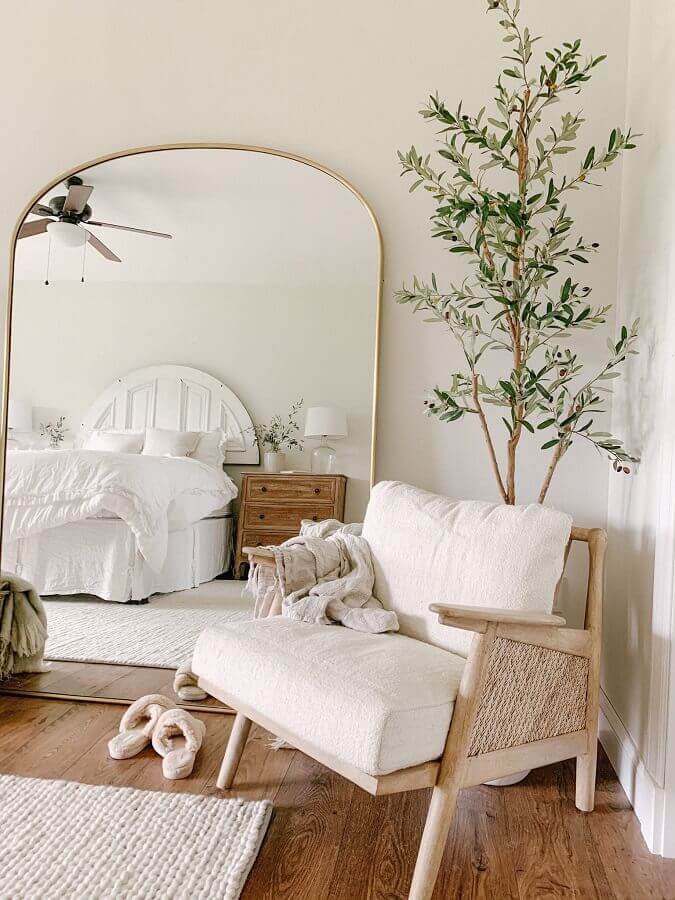 Espelho grande no quarto decorado em cores claras com poltrona de madeira Foto Home Decor Ideas
