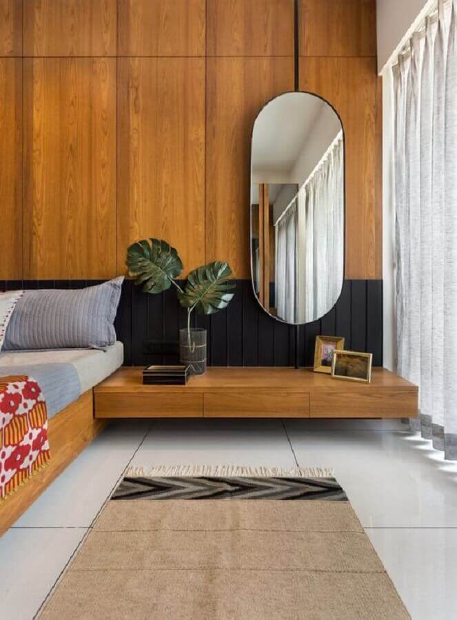 Espelho no quarto de casal decorado com parede de madeira Foto Architectural Digest