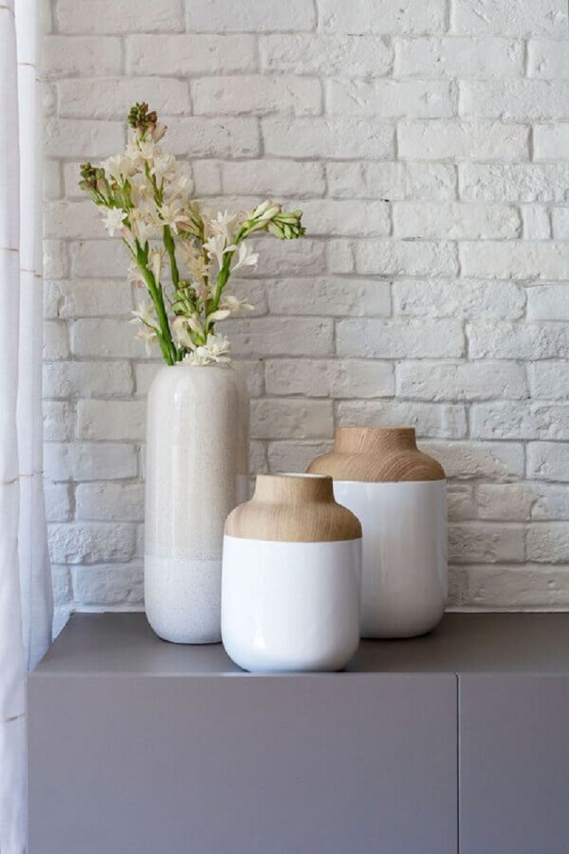 Objetos minimalistas para decorar sala de estar com parede de tijolinho branco Foto Mira Studio