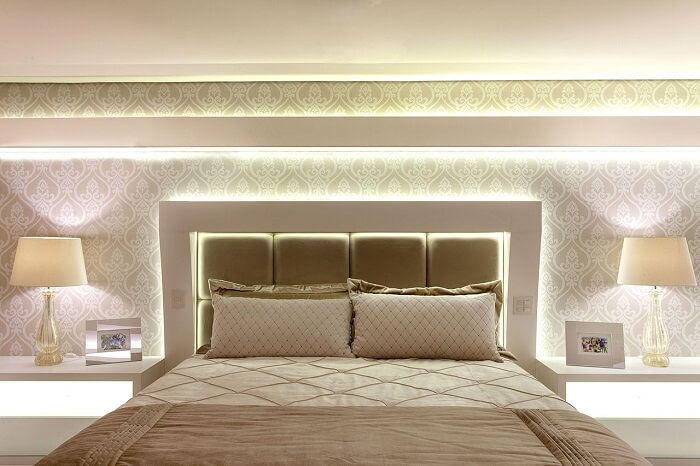 Projeto sofisticado de quarto de casal com cabeceira com LED. Fonte: Iara Kilaris