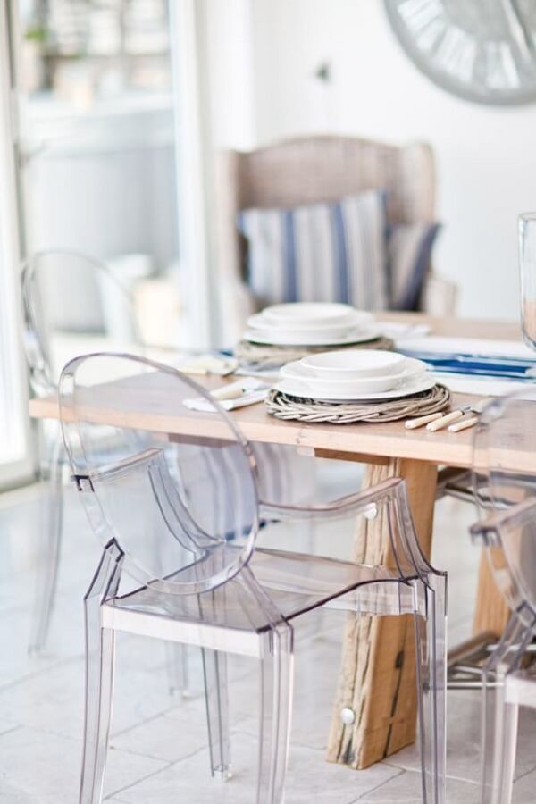 Sala de jantar com cadeira acrilico transparente e mesa de madeira 