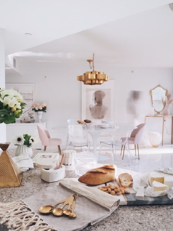 Sala de jantar com cadeira acrilico transparente e pendente rose gold 