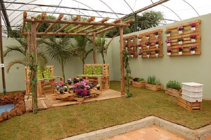 Área de lazer decorada com jardim vertical externo com paletes. Fonte: Amigos de Leilanina