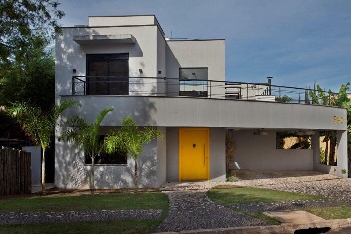 Casa com facada cinza e porta de entrada amarela