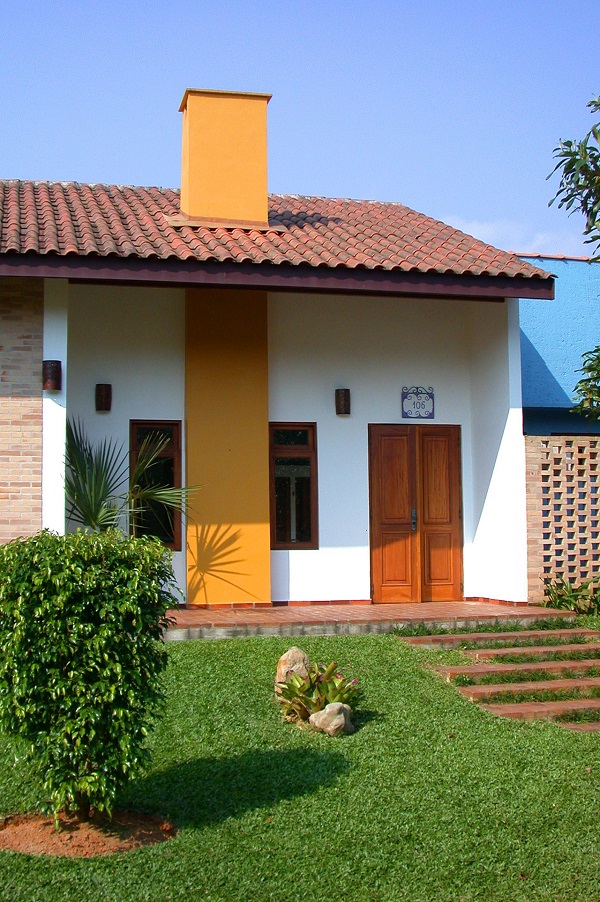 Casas rústicas com jardim e revestimentos modernos na fachada
