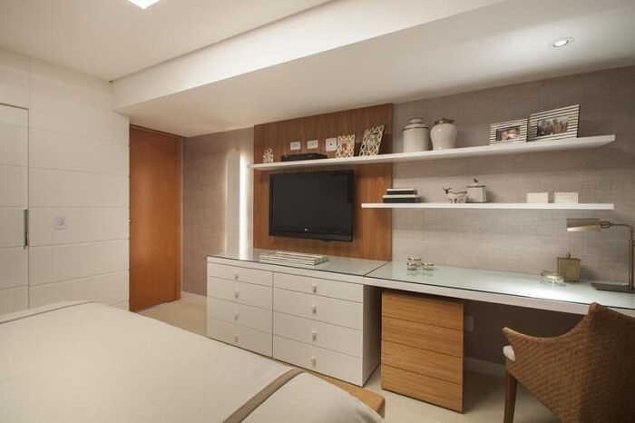 Escrivaninha de madeira e painel para tv no quarto. Fonte: MeyerCortez Arquitetura & Design