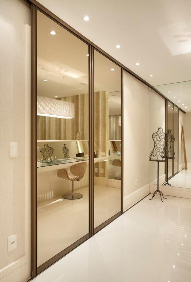 Guarda roupa com porta de vidro espelhado no closet moderno