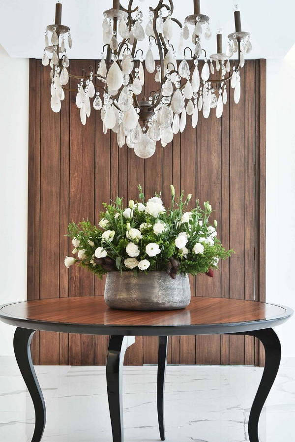 Hall de entrada simples com mesa de madeira e vaso de flores brancas