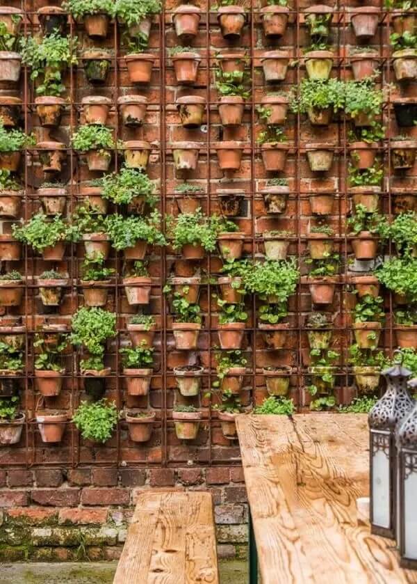 Jardim vertical externo de quintal decorado com diversos vasos de plantas. Fonte: Le Journal des Femmes