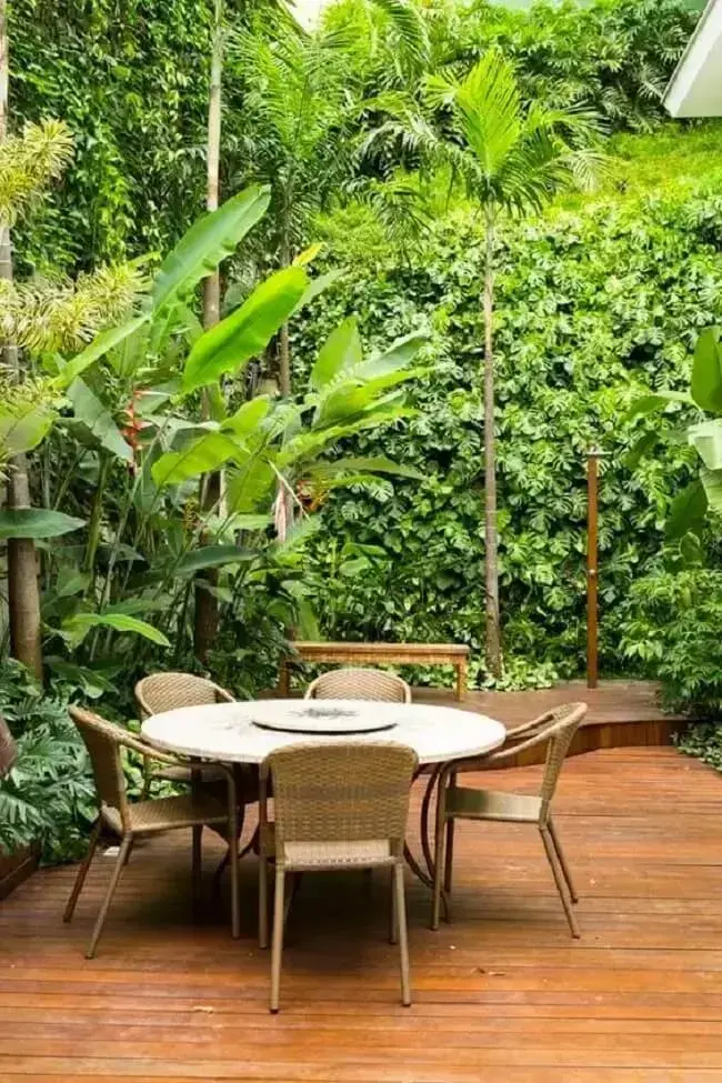 Mesa de jardim redonda e jardim vertical externo decoram o espaço. Fonte: Revista Casa e Jardim