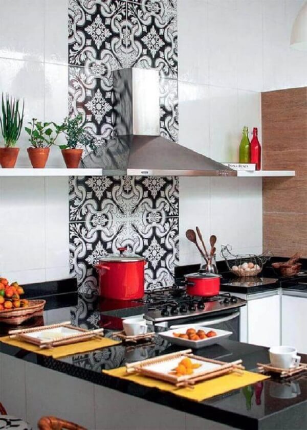 Pedra para cozinha na cor preta com armários brancos e adesivo na parede do fogão
